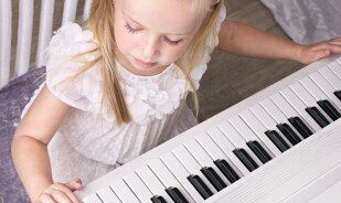 little girl playing on piano